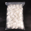 A clear plastic bag filled with numerous white, compressed cleansing towels.