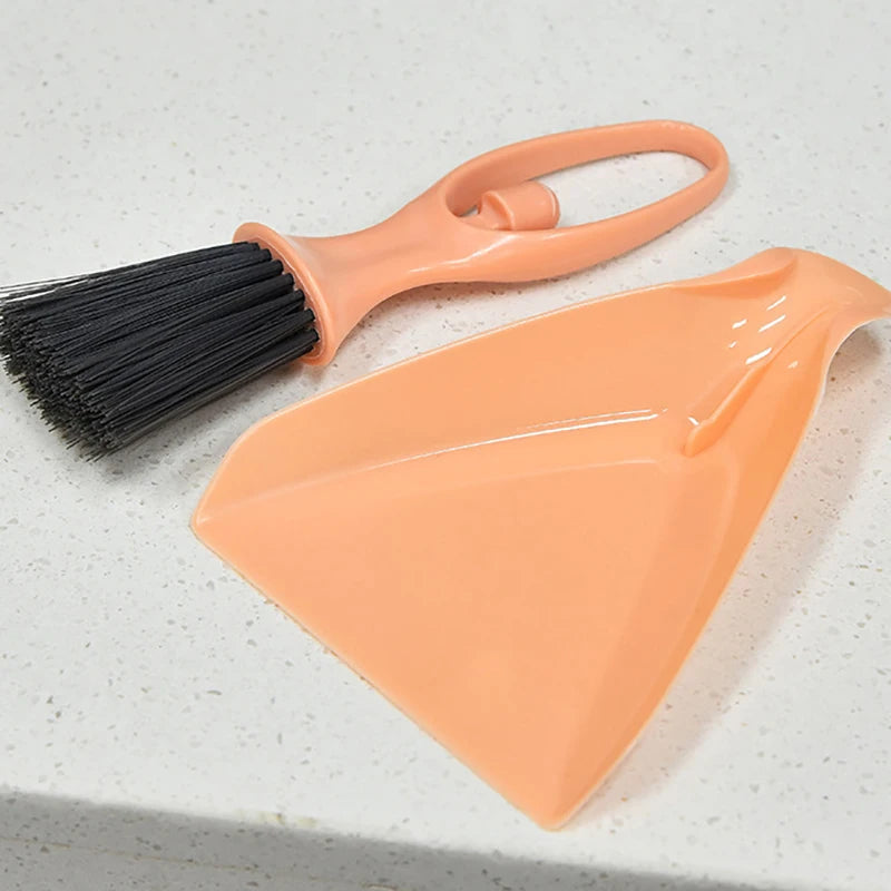 An orange compact mini broom and dustpan set with a handle and a flat pan for cleaning