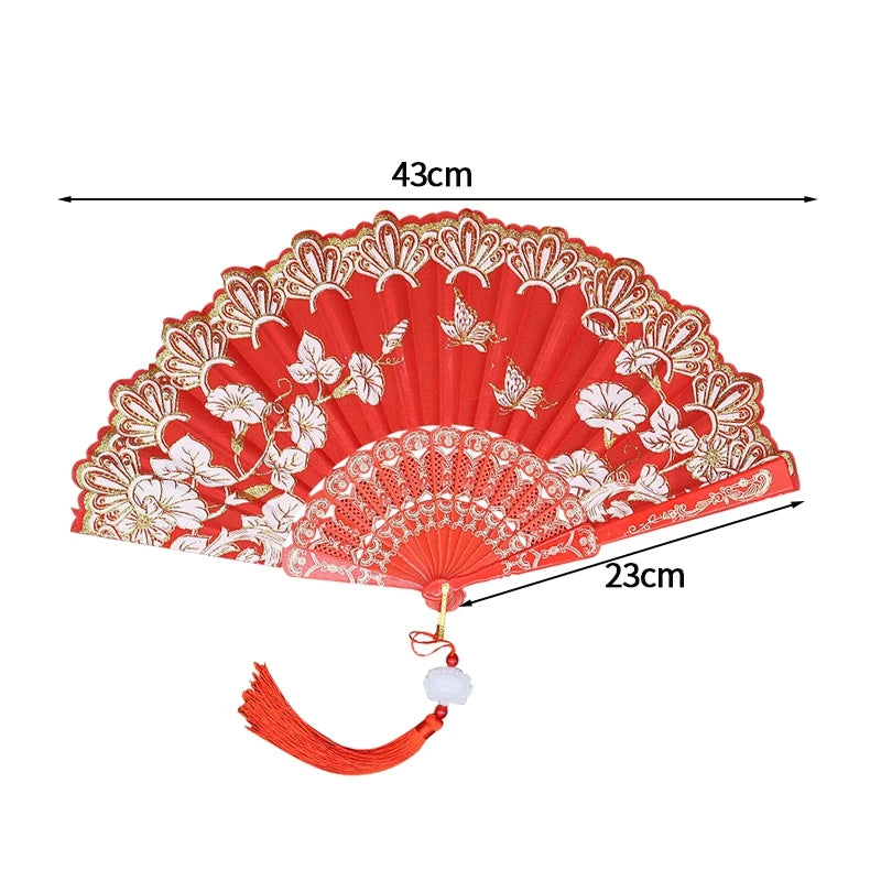 Red folding fan with white floral patterns and a golden lace trim