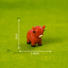 An orange resin figurine of a Highland cow, measuring 2cm high and 1.4cm wide, resting on green moss.