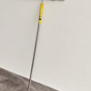A silver paint roller with a yellow handle is mounted on a wall, ready for use.