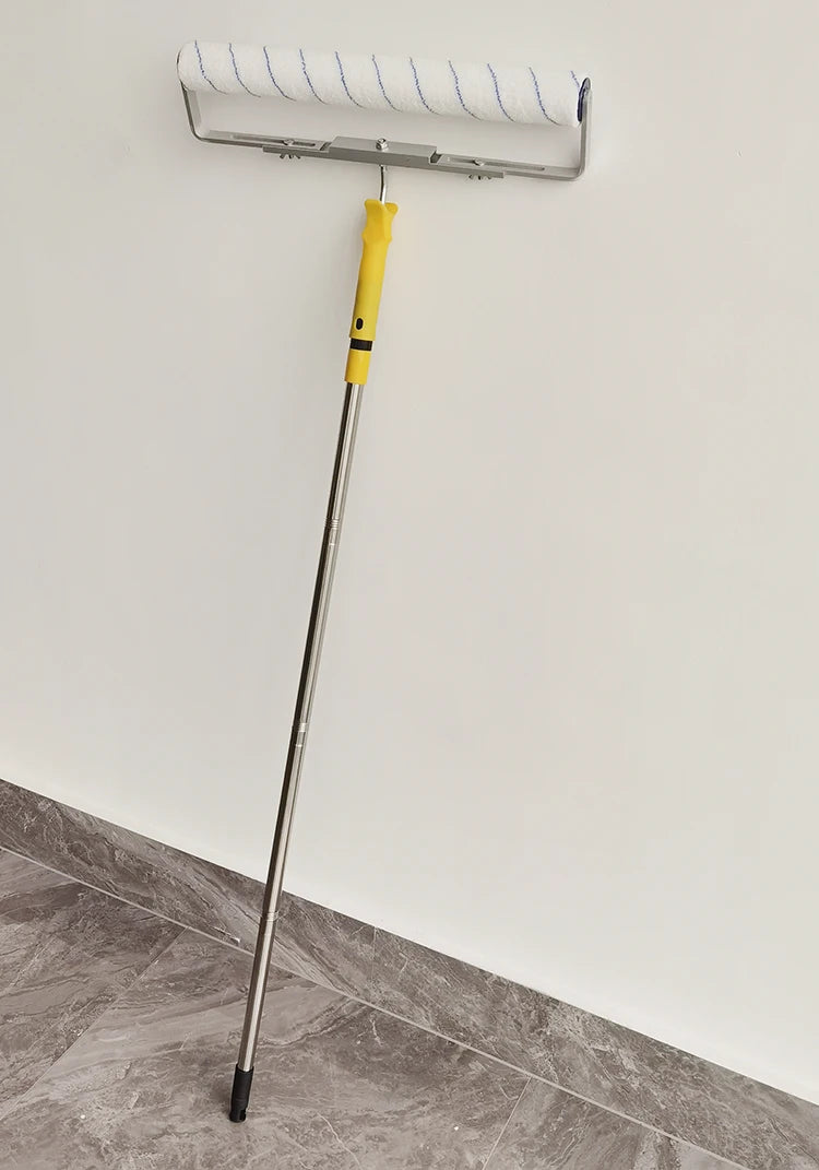 A silver paint roller with a yellow handle is mounted on a wall, ready for use.