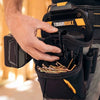 A hand is holding a black ToughBuilt tool belt with multiple pockets and gold tools.