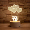 A glowing LED night light lamp featuring heart-shaped silhouettes of the word LOVE made from wire mesh.