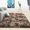 A luxurious brown velvet plush carpet placed on a light wooden floor in a modern living room setting.