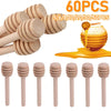 60 pieces of natural wood honey dipper sticks in various sizes and a golden honey drop