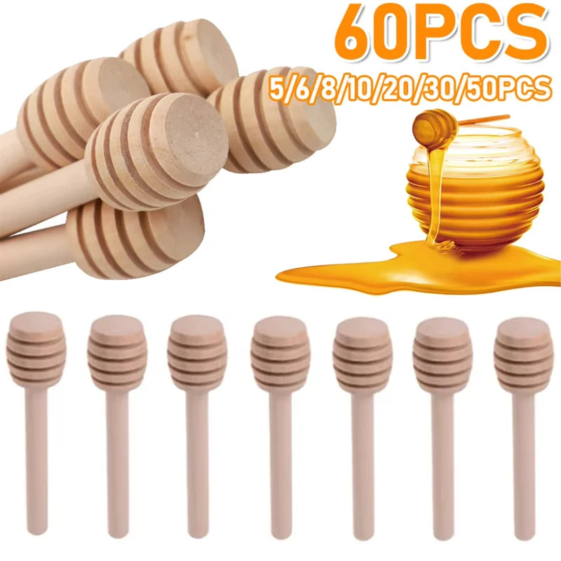 60 pieces of natural wood honey dipper sticks in various sizes and a golden honey drop