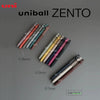 A collection of Uni ZENTO gel pens in various colors and thicknesses, shown against a gray background.