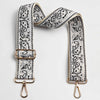 A beige and black paisley jacquard bag strap with gold-toned hardware.