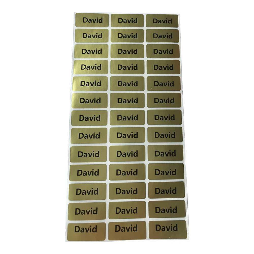 A grid of thirty personalized matte gold name stickers for kids' belongings.