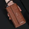 Portefeuille à fermeture éclair en cuir marron pour homme tenu dans une main sur fond sombre.