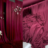 Elegant burgundy stretch jersey fabric draped as a luxurious backdrop or decor