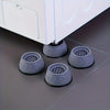 Three gray anti-vibration pads used as shock absorber feet for a white washing machine or dryer.