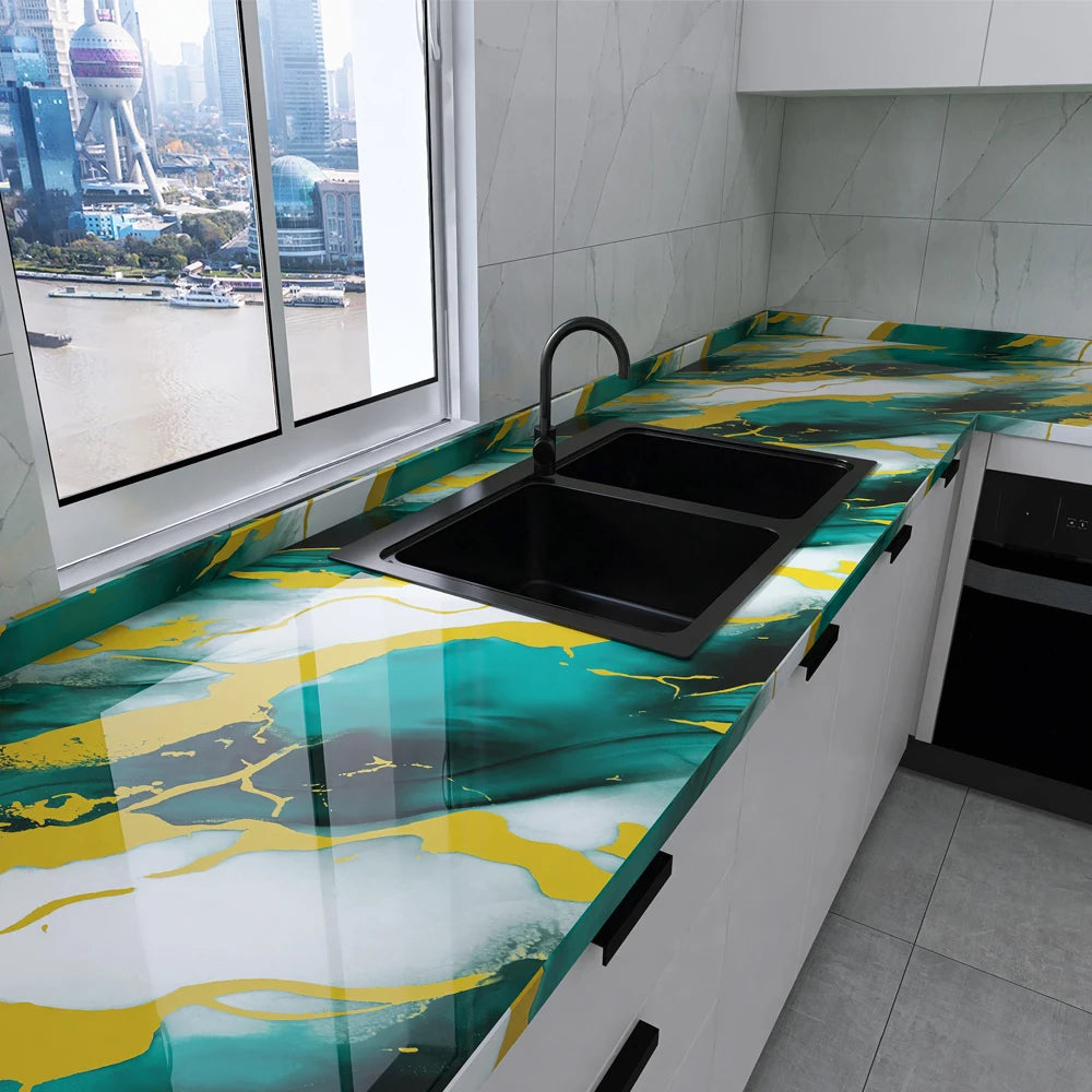 A kitchen countertop featuring a marble peel-and-stick wallpaper with abstract yellow and teal patterns.