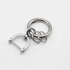 Silver metal key fob cover with a split ring and a loop for a Nissan car key.