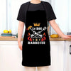 A person wearing a black apron with a gold crown and BBQ theme on the front