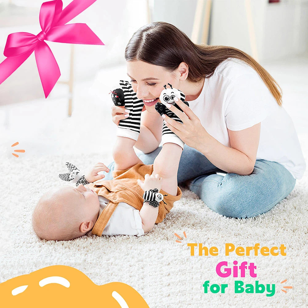 A woman gently plays with a baby using a soft rattle set featuring wrist and foot finders.