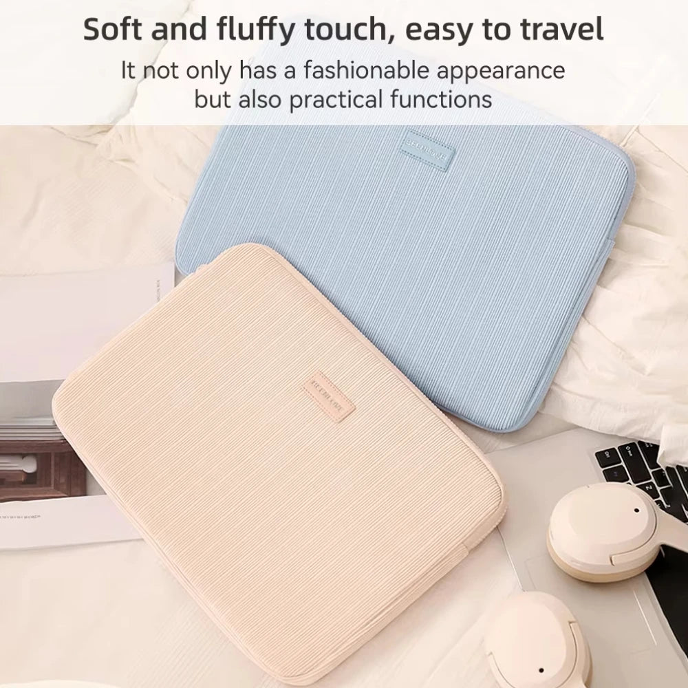 Una funda protectora azul claro y beige para portátil, apoyada sobre ropa de cama blanca.