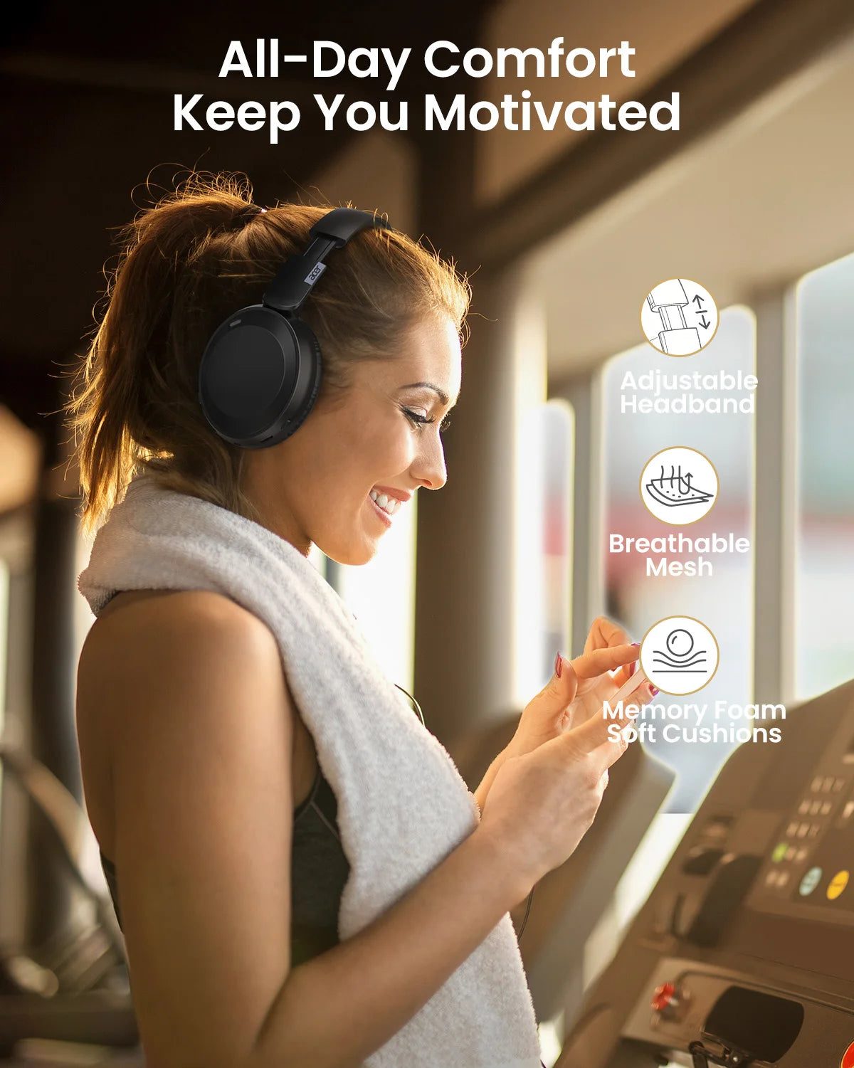A woman wearing a gray knitted garment and headphones is smiling while using fitness equipment.