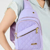 A purple quilted crossbody sling bag with a gold zipper is worn by a person in a light blue shirt.