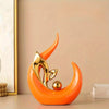 An orange ceramic sculpture shaped like a stylized horn or curl, with a gold metallic accent.