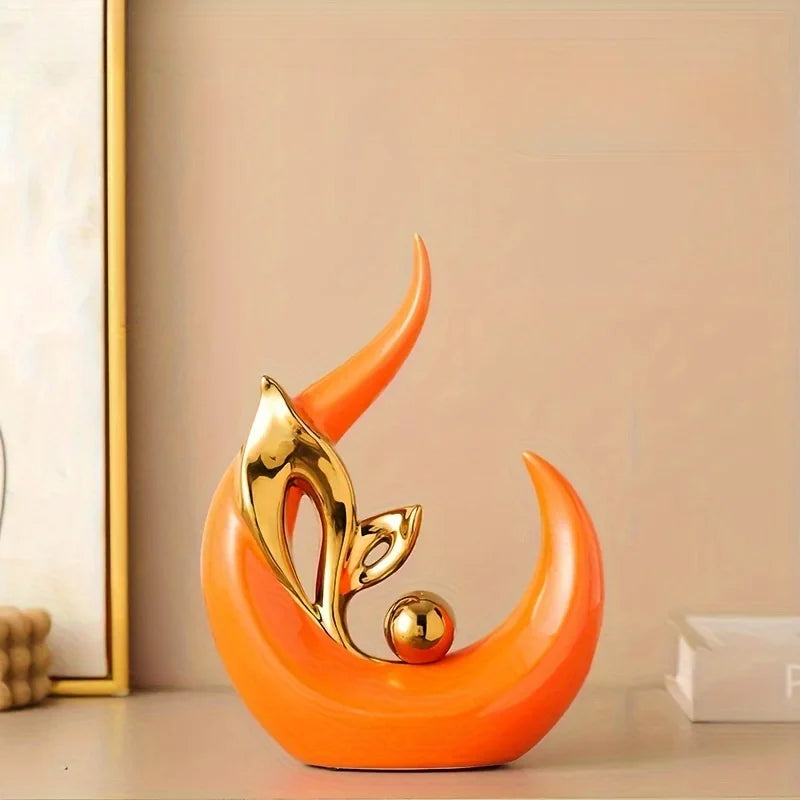 An orange ceramic sculpture shaped like a stylized horn or curl, with a gold metallic accent.