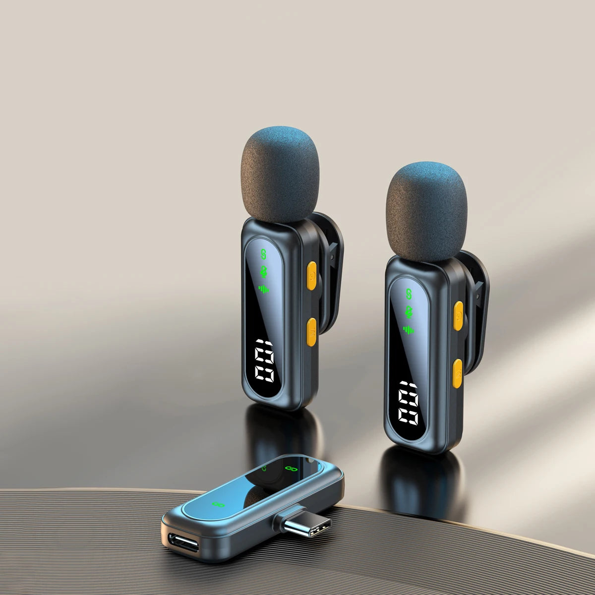 A pair of black wireless lavalier microphones with green indicator lights resting on a surface.