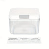 Clear plastic automatic pop-up laundry pod holder with a silver lid.