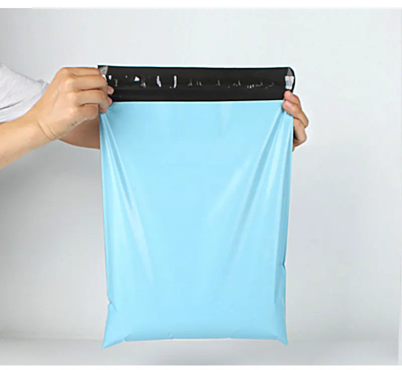 A hand is holding a light blue heavy-duty waterproof poly mailer bag with a black measuring tape on top.