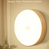 A round, illuminated sensor light fixture mounted on a wall, showing a soft white glow.