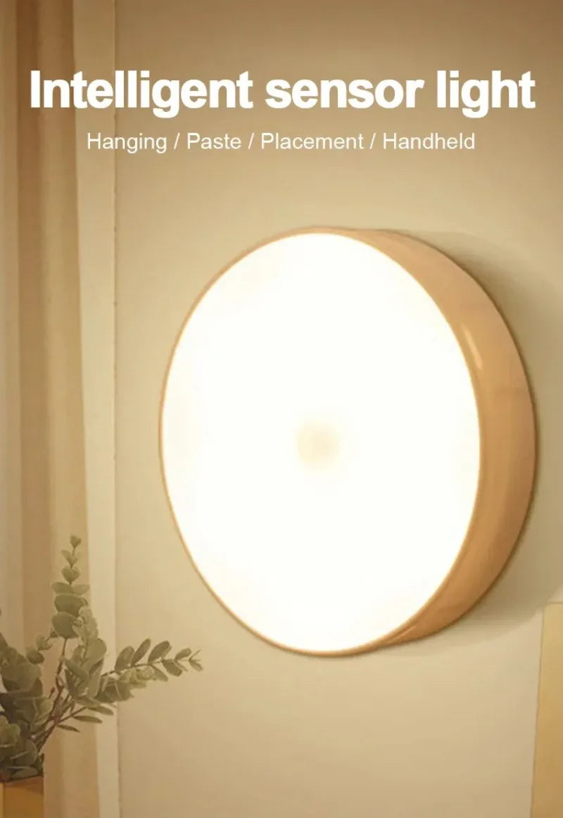 A round, illuminated sensor light fixture mounted on a wall, showing a soft white glow.