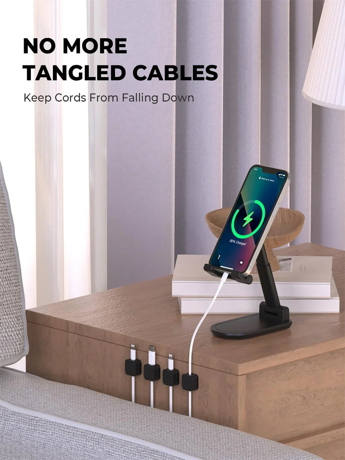 Magnetic cable clips with adhesive backing holding charging cables neatly on a wooden table.
