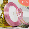 Pink gold-edge satin ribbon rolled on a stand for crafts and gift wrapping
