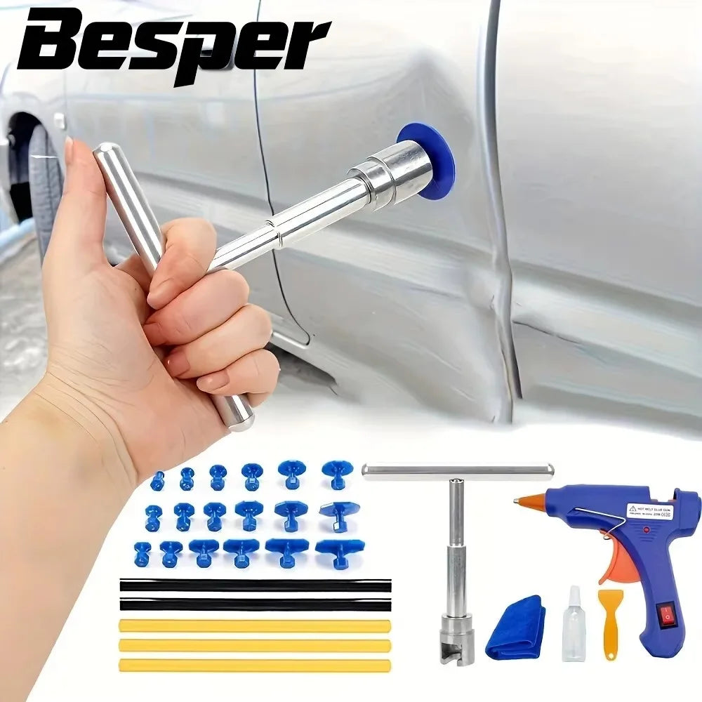 A hand holds a paintless dent repair tool with an adhesive tab against a silver car body.