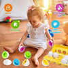A toddler is sorting colorful Easter egg shape puzzle toys into a yellow tray.