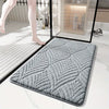 A gray plush velvet bathroom mat with a non-slip backing is shown on a white marble floor.