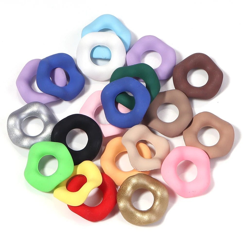 A collection of colorful acrylic spacer beads in a wave pattern, including shades of purple, blue, green, pink, and brown.