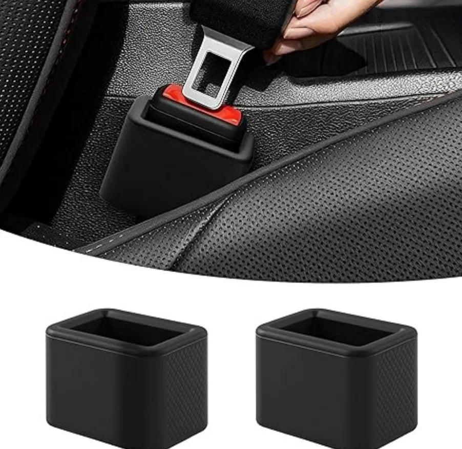 A close-up view of a black car seatbelt buckle protective cover being installed on a seatbelt, with two spare covers shown be