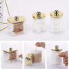 Elegant apothecary jar with a golden lid for storing cotton balls and swabs.