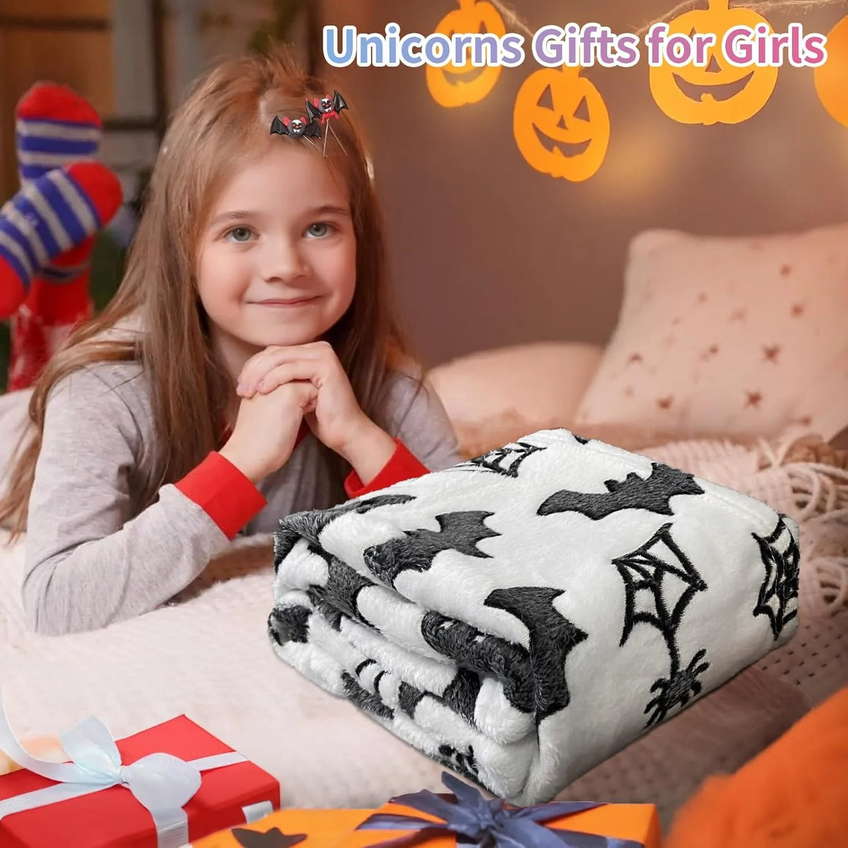 Junge mit Lächeln, die ein schwarz-weißes batmusteriges Korallen-Fleece-Halloween-Decke hält.