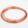 A coil of bare copper wire with multiple diameters laid out in a circular shape.