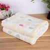 A stack of cozy flannel pet blankets featuring a cartoon elephant pattern in pastel colors on a wooden surface.