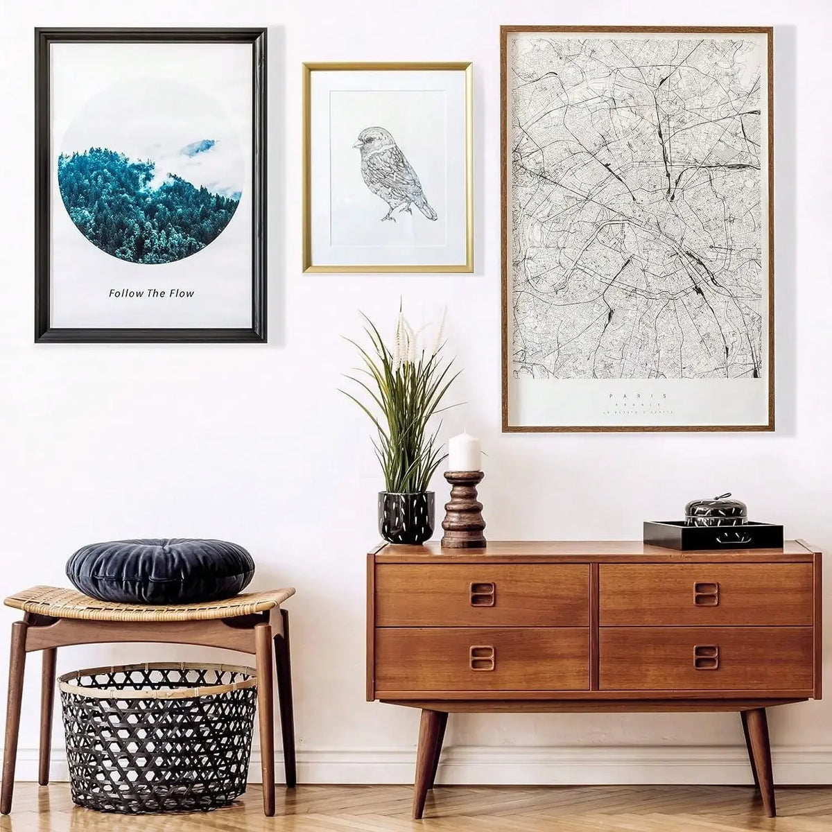 A gallery wall featuring framed artwork, including a blue landscape print and a black and white line drawing, displayed on a 