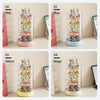 Four rotating transparent display cases for collectibles in pink, blue, yellow, and beige.