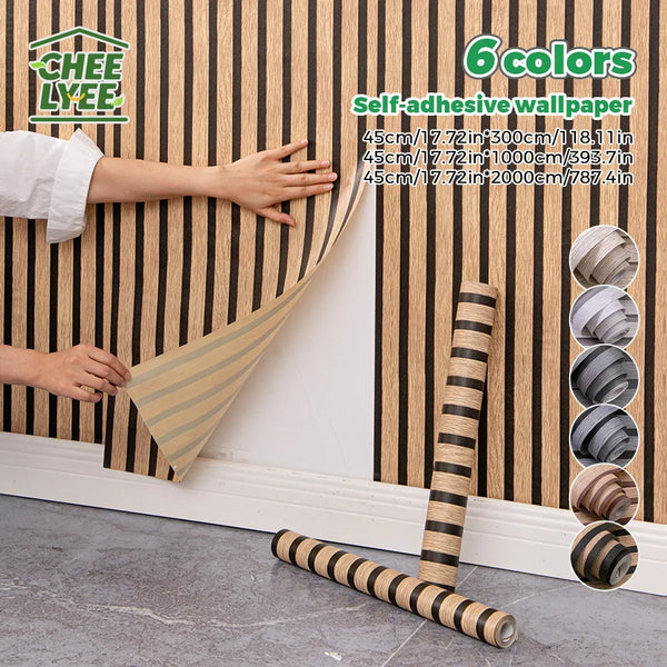 Roll of self-adhesive wallpaper in striped beige and brown tones being applied to a wooden wall surface.