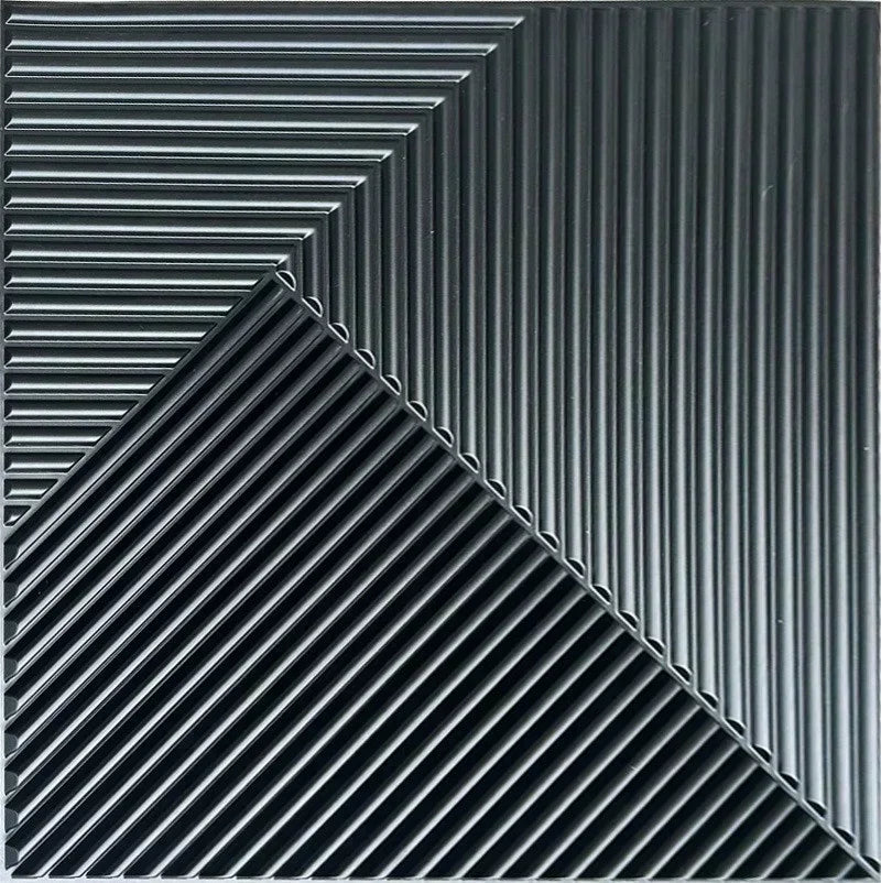 A close-up view of black, ribbed 3D diamond wall panels arranged in a sharp diagonal pattern.