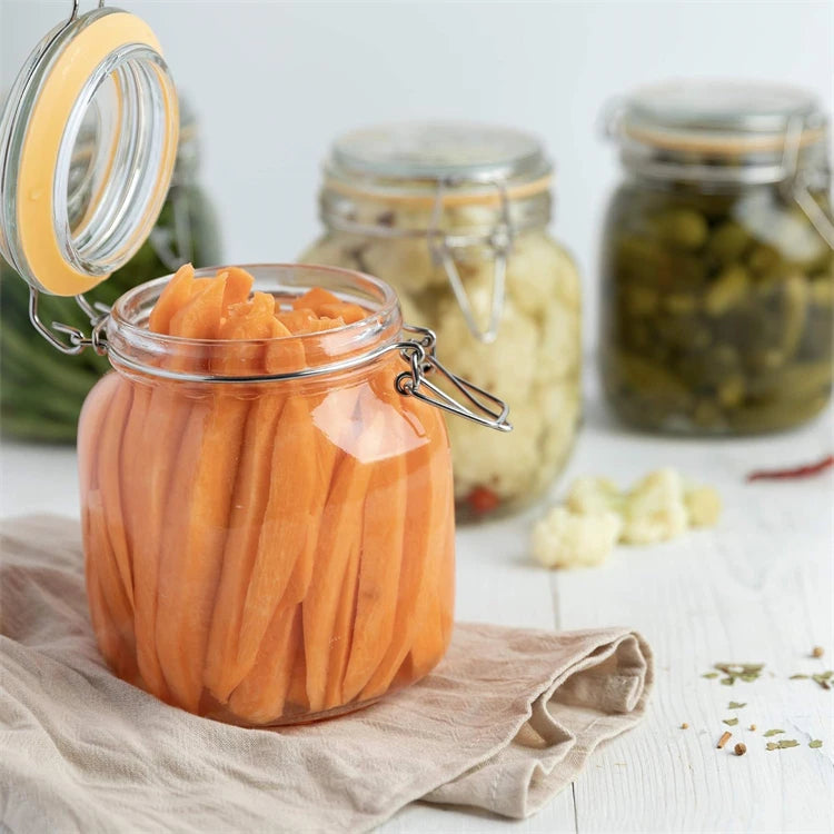A glass jar filled with bright orange carrots resting on a linen cloth.