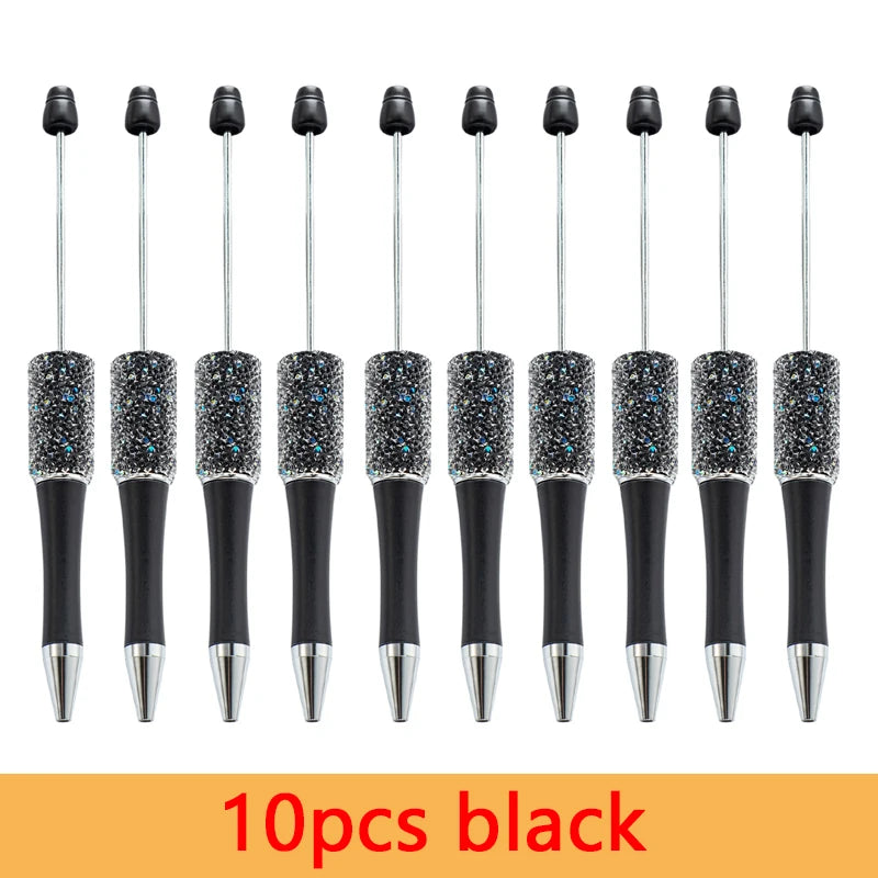 A set of ten black beaded ballpoint pens arranged in a row.
