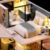 A miniature wooden dollhouse building kit with furniture displayed on a wooden table.