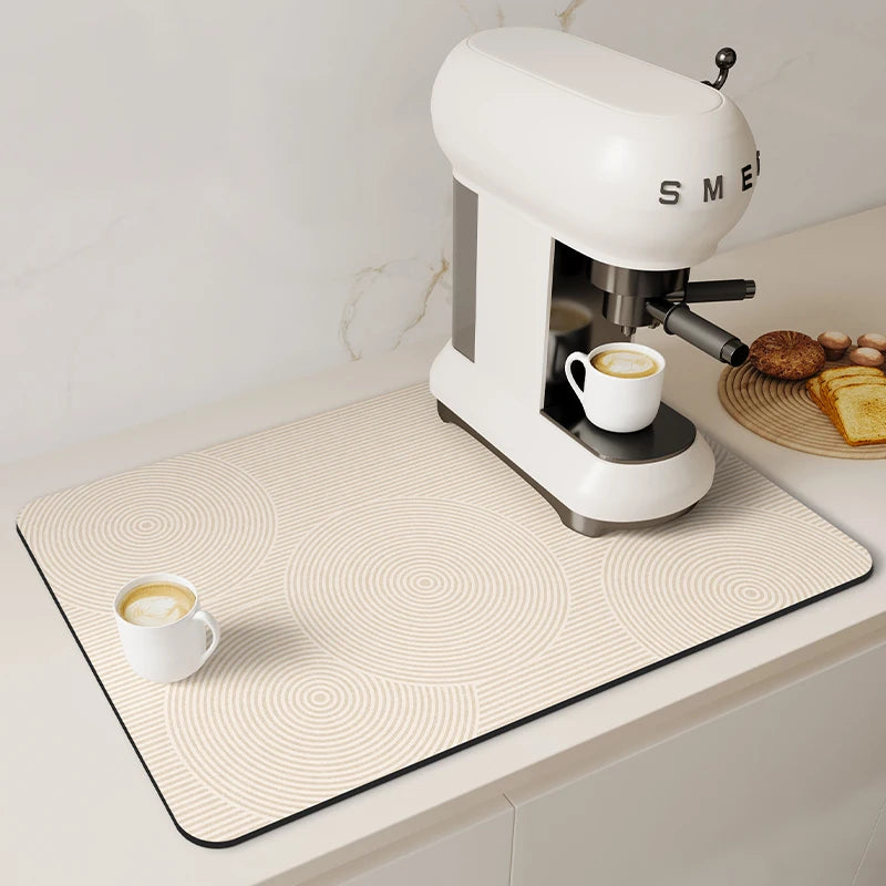 A white espresso machine sits on a beige counter mat with a subtle circular pattern.